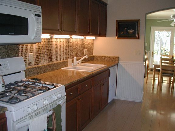 kitchen in cinnamon maple, with granite counters and tile backsplash