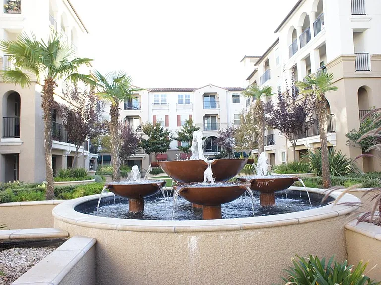 Courtyard area with several water fountain and sitting bench offering area for relaxation around the community