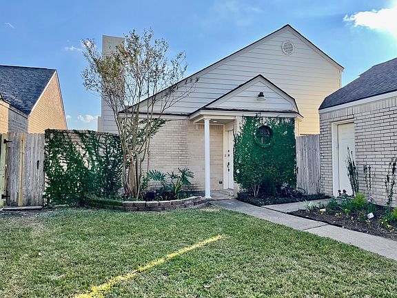 Front door and porch. Detached garage to the right with separate entrance.