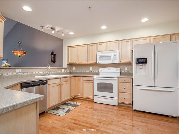 Spacious kitchen has hardwood floors, Corian countertops