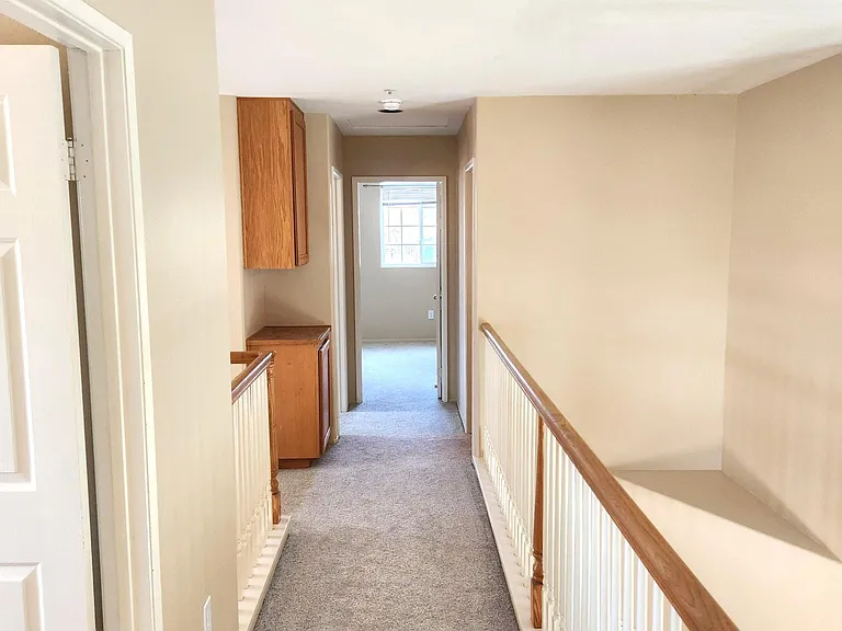 Looking back down the upstairs hallway from the primary bedroom.