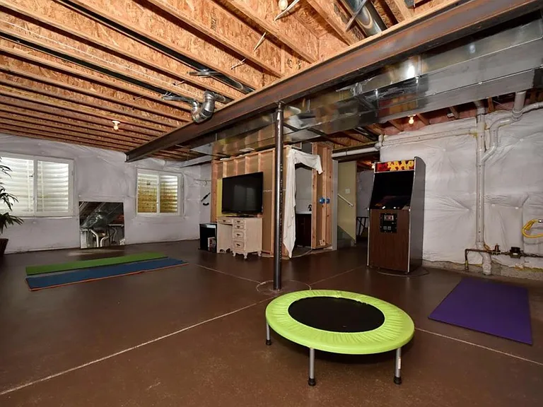 Basement with stained concrete floors, half bath and storage
