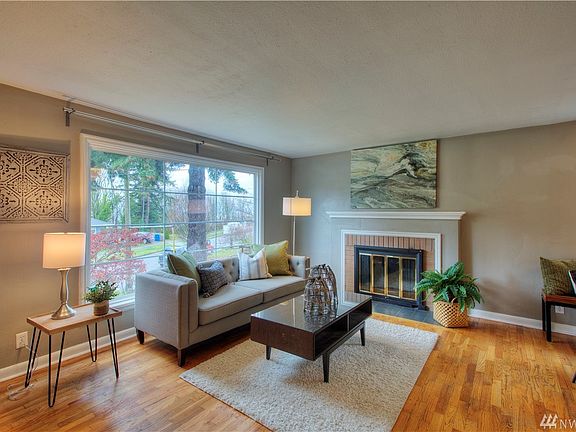 Living room with tons of natural light and fireplace to keep things cozy. 
