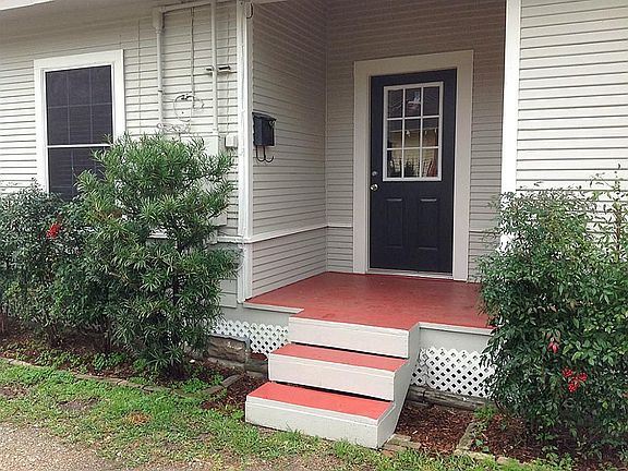 Cute red front steps and porch lead to the front door.