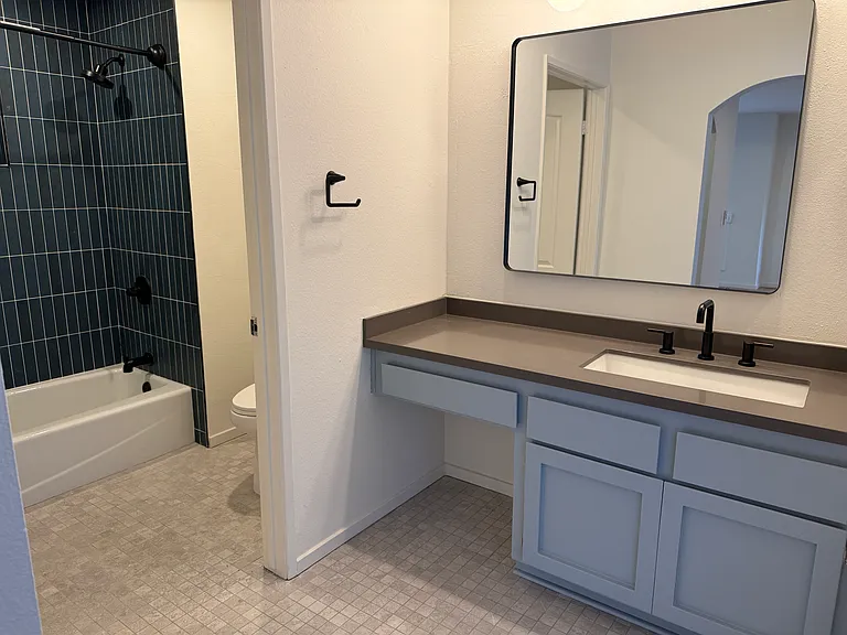 Brand new tub, newly tiled tub surround, and bathroom floor with all new fixtures. Unit 207