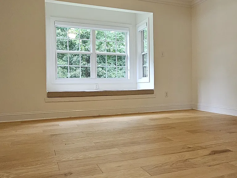 Primary suite offers a tray ceiling, abundant natural light, and a charming built-in window bench with storage.