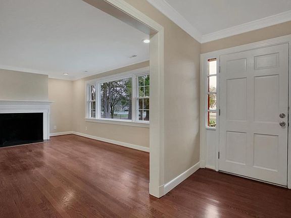 Wide, elegant entryway/foyer with crown moulding and custom paneled front door.