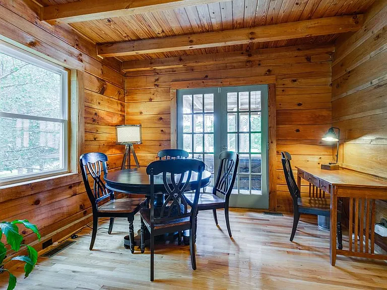 Table for four and desk with chair in cabin living room. Sofa is a pullout sofa.
