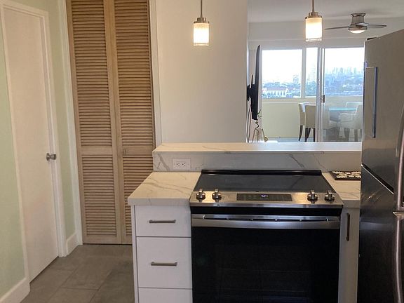 Kitchen with views out to the lanai and beyond! Washer/dryer laundry stack hidden inside bifold door closet.