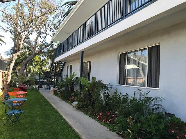 Midcentury building with landscaped courtyard maintained by weekly gardener. Cafe tables and chairs.