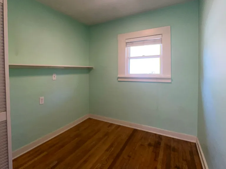 Bedroom in the house with two small closets and original wood floor.