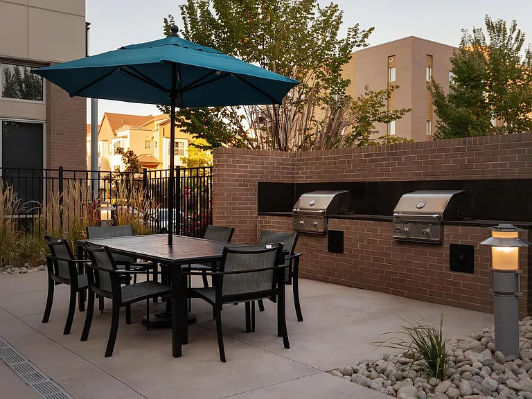 Outdoor Grilling Station with Shaded Dining Table and Stainless Steel Grills