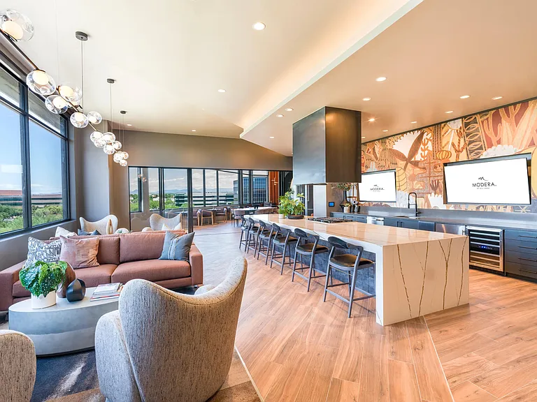Host or unwind in the beautifully designed demonstration kitchen and lounge, featuring modern finishes, ample seating, and integrated entertainment displays.