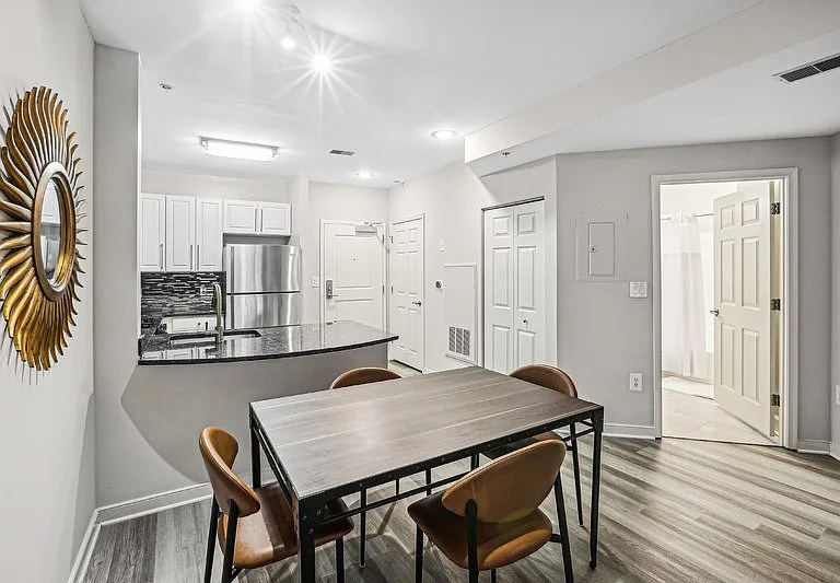 Open Layout with View of Kitchen, Dining Table, and Apartment Entrance