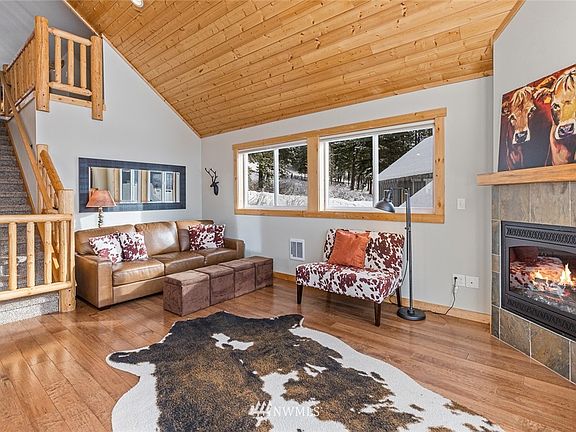 Custom log railing leads to the open loft space.