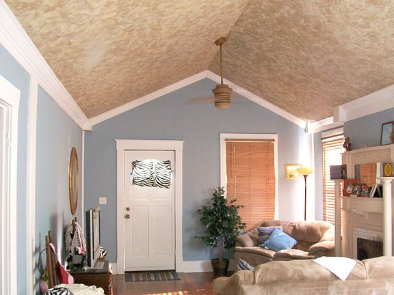 The living room has cathedral ceilings and a beautiful victorian fireplace