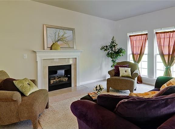 Gorgeous great room with a wall of windows and fireplace opens to the kitchen.