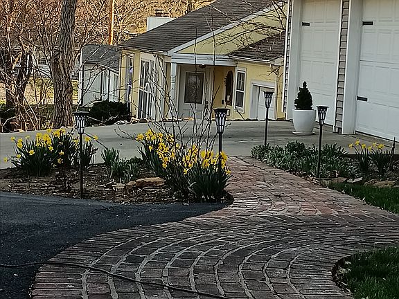 Front yard landscaping with brick path.