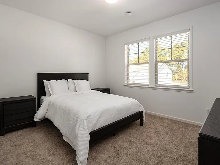 Queen-size bedroom with windows that fill the space with natural light.