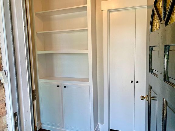 Entry way with built-in book shelf and double doors to separate bonus room.