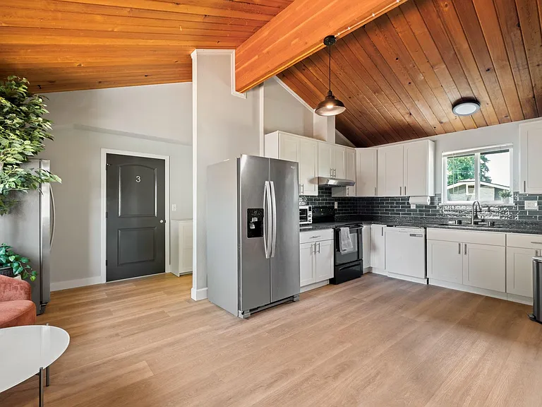 Spacious kitchen with ample white cabinetry, stainless appliances, and a large window over the sink for everyday prep.