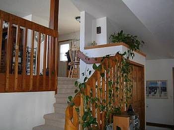Warm oak railing over looking family room