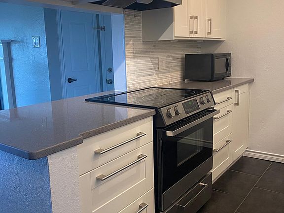 Updated kitchen with quartz countertops, marble backsplash and stainless steel appliances.