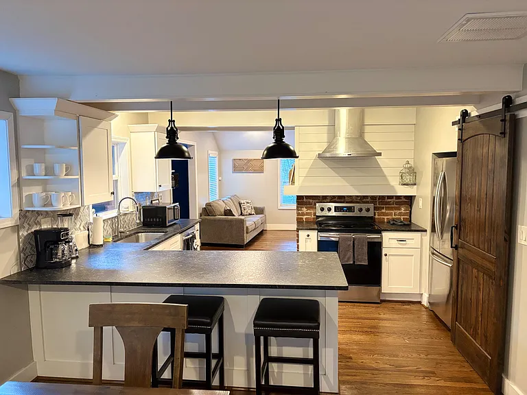 Eat-in kitchen with a large breakfast bar, ample cabinetry, and stainless appliances, opening to the living area.