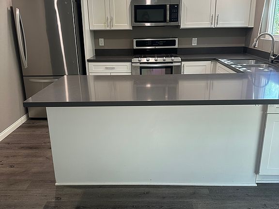 Recently remodeled kitchen with quartz countertops, stainless sink, and stainless appliances