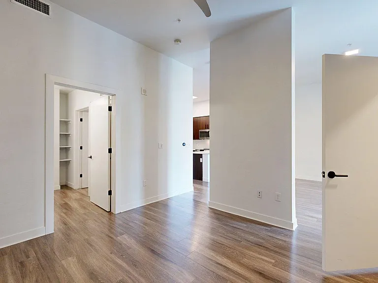 Spacious apartment Bedroom with Large Closet, Attached Bathroom and light wood flooring
