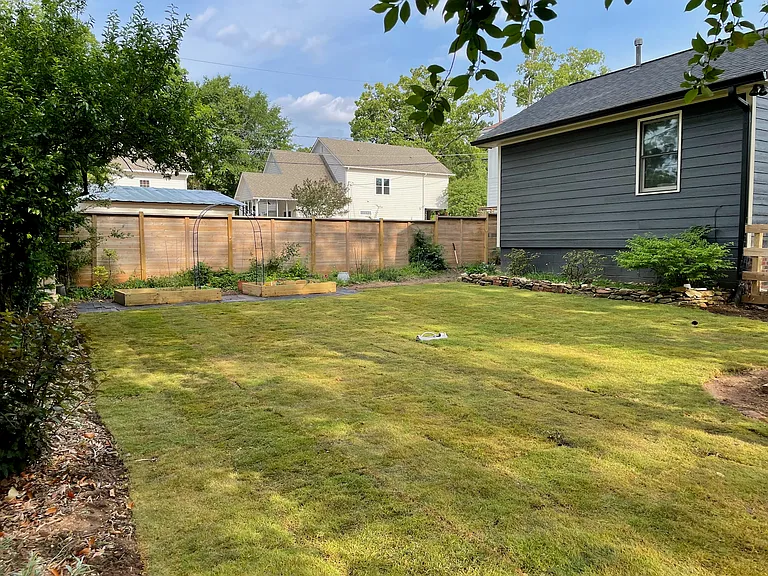Fenced back yard with garden beds