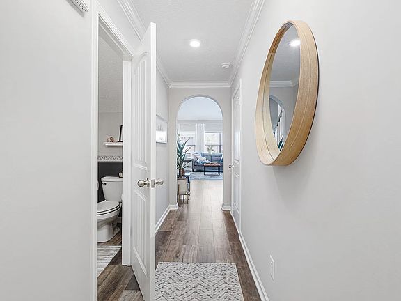 When you enter, you will see a storage space and a half bathroom on the left_The door to the garage is on the right and directly ahead is the huge vaulted ceiling living room.