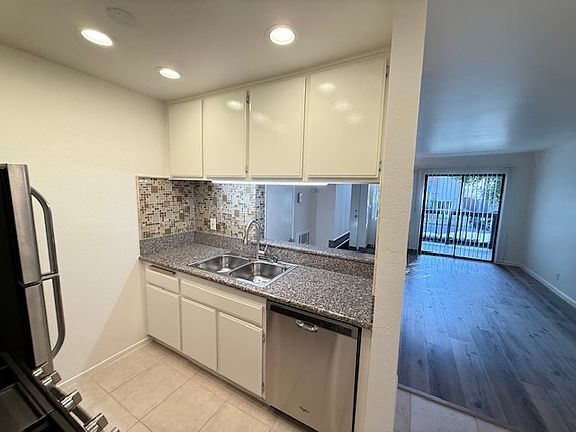 Kitchen with granite countertops and under cabinet lighting.