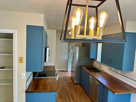 Galley kitchen underneath the modern lighting includes new LG stainless steel convection oven, microwave, dishwasher, disposal, gourmet sink and massive modern refrigerator, with over-sink lighting.