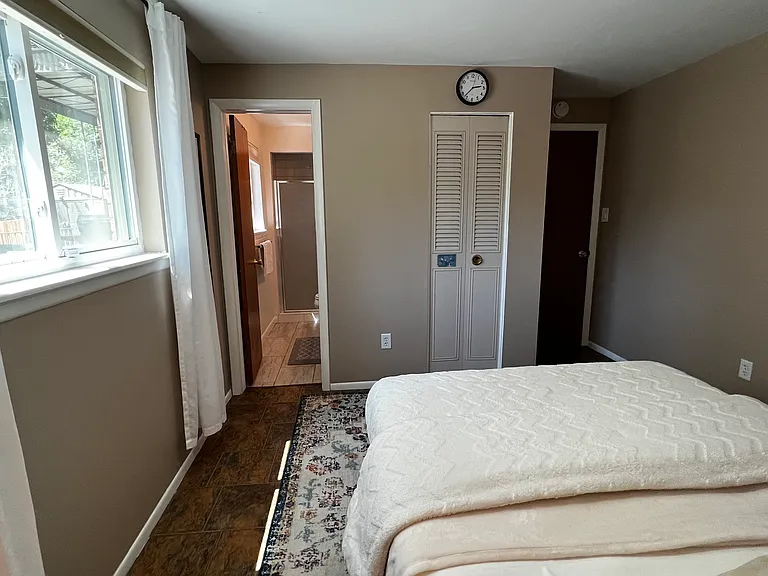Alternate view of the garden-level bedroom showing the direct path to the attached bathroom.