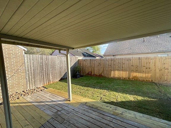 Large covered patio with huge wooden deck. Added fresh grass to backyard and notice the newer fence in back.