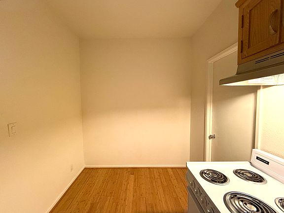 Kitchen with useable space to the left of the oven and cabinets for storage, small table, or bar stool seating.