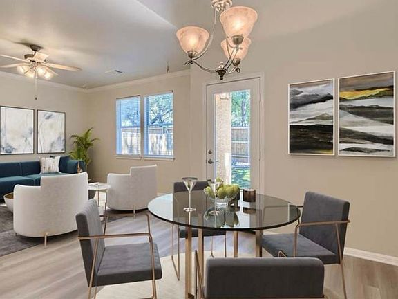 Living room view from dining area with tall lofted ceiling and large upper windows.
