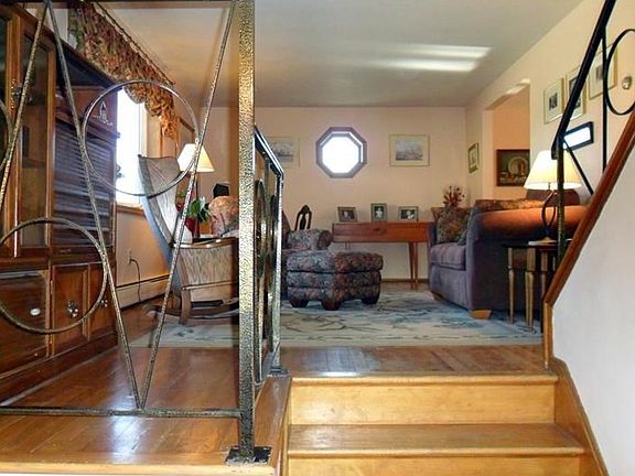 View of the 19'x 11' living room from the entry hall with hardwood floors and picture window