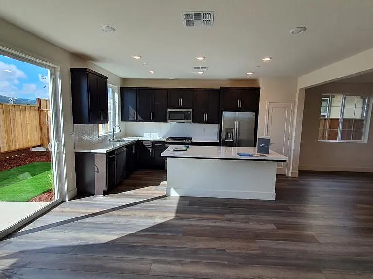 Living room with open kitchen and dining area to the right. Brand new GE appliances.