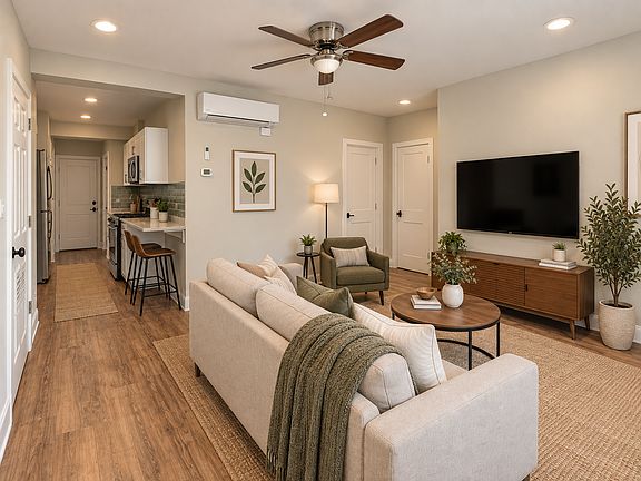 Living room overlooking the street and open to the kitchen. Furniture is staged, offered unfurnished.