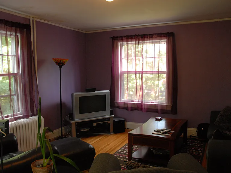 Other side of large living room. Paint color is more neutral, a light tan