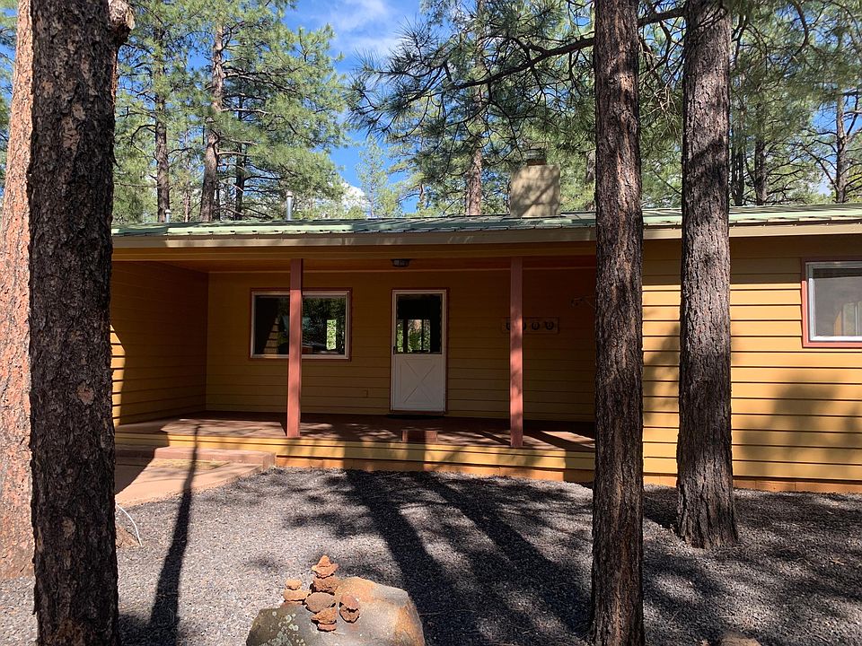 Custom three color paint on exterior of home with barn wood and cedar lined carport.