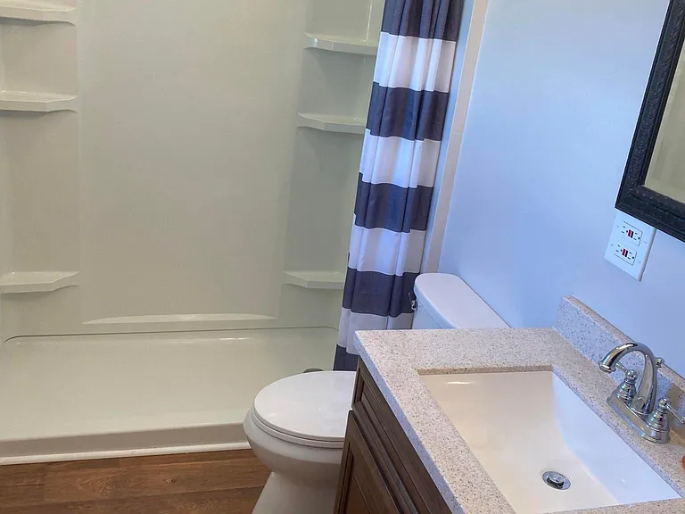 Double shower stall with tankless water heater for instant hot water
