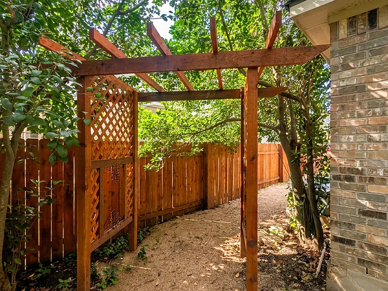 Pergola-covered side yard with privacy fencing
