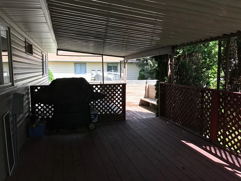 Covered deck looking at the BBQ and hot tub area