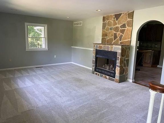 Family room with new carpets, fresh paint. See through stone gas fireplace.