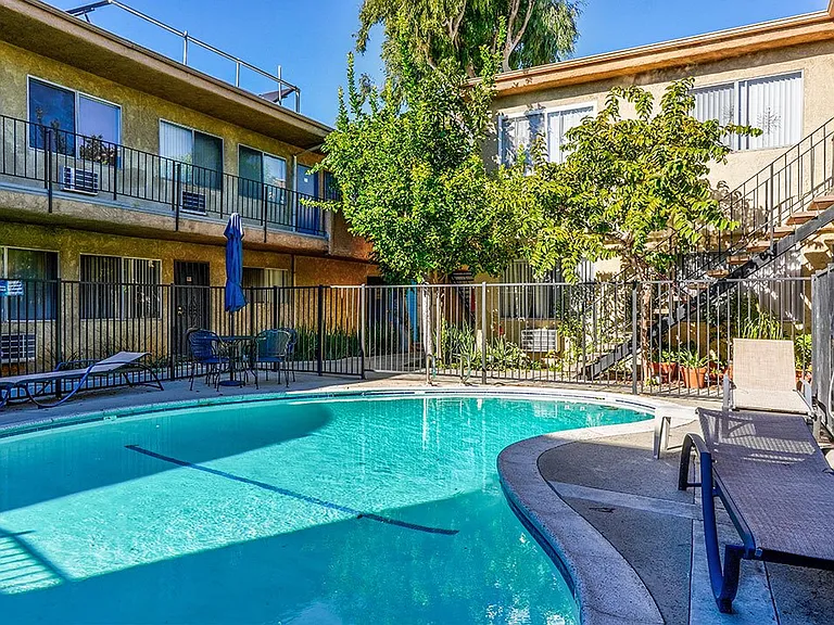 View of gated community pool with lounging space.
