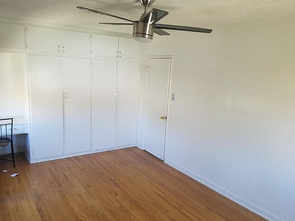 Tons of closet space and built-in desk and ceiling fan in this oversized bedroom! New white blinds, too!