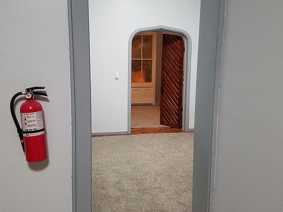 A view of the living room and one of the bedrooms in the background.